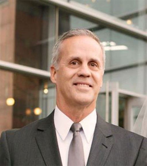 A man in suit and tie standing outside of building.