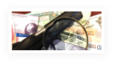 A blurry image of money and magnifying glass.
