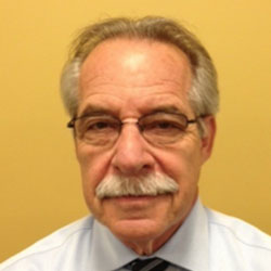 A man with glasses and a mustache wearing a tie.