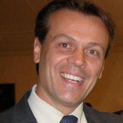 A man in suit and tie smiling for the camera.